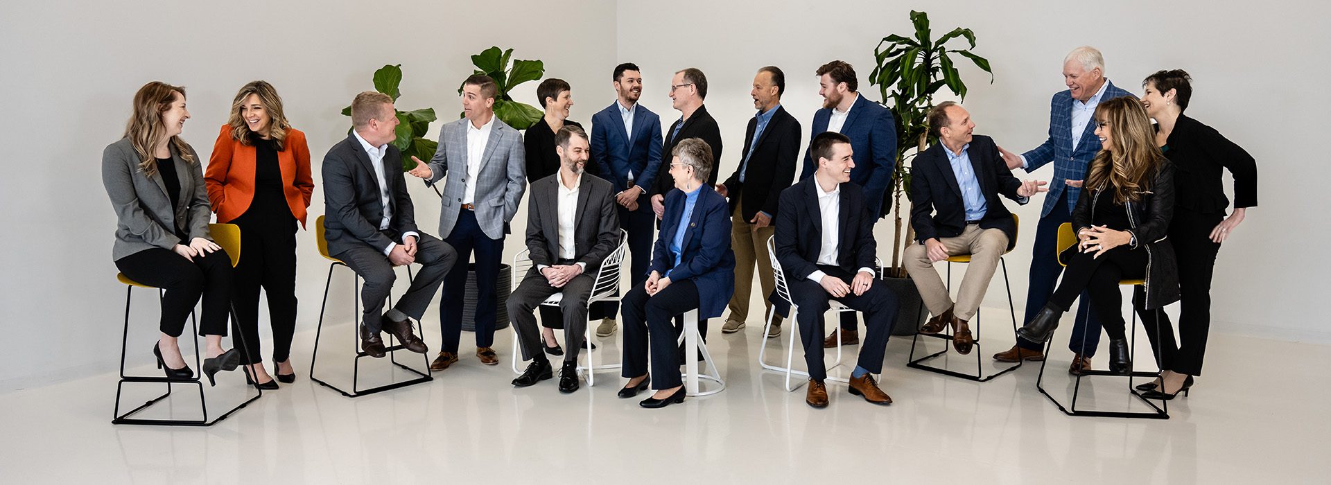 Meet Our Team - BCF Group Team Sitting and Smiling Together for a Casual Photo in a White Room